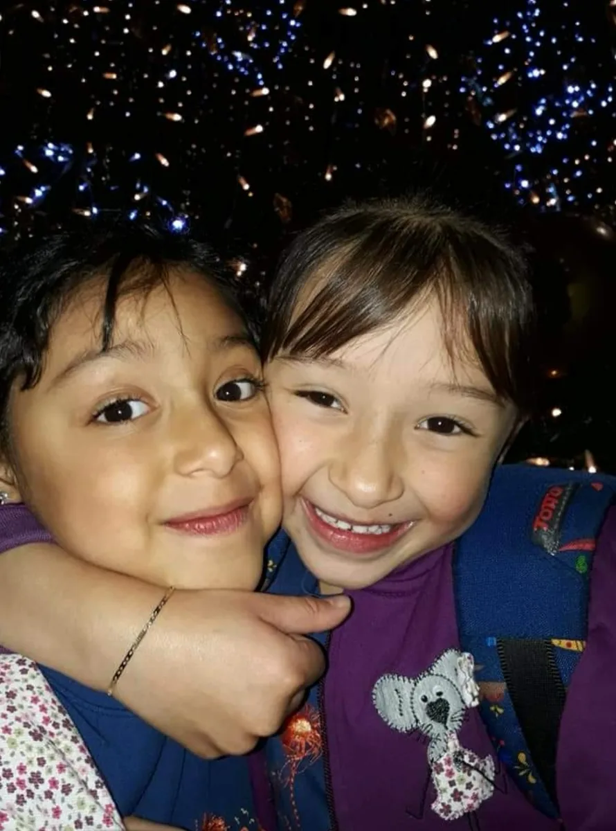 Mafe y Sofi abrazadas frente a luces